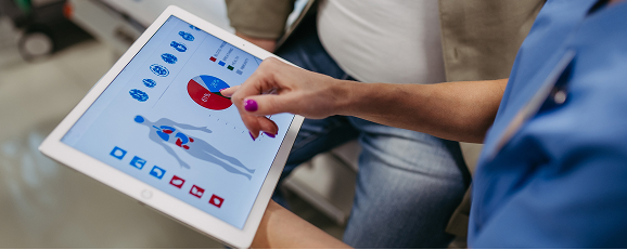 a healthcare professional looking at a tablet screen displaying patient data