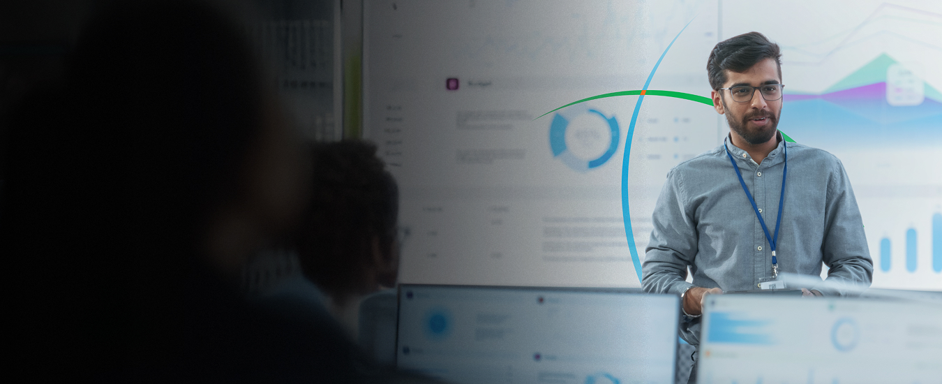 banner showing a man delivering a presentation while standing in front of a large screen displaying analytics-driven insights